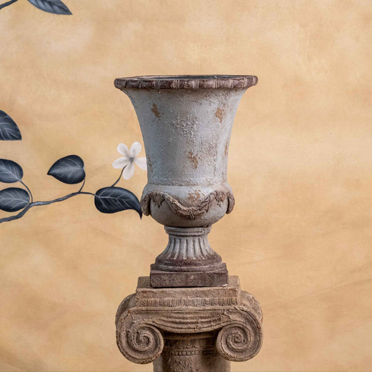 Decorative urn with floral elements on a beige background