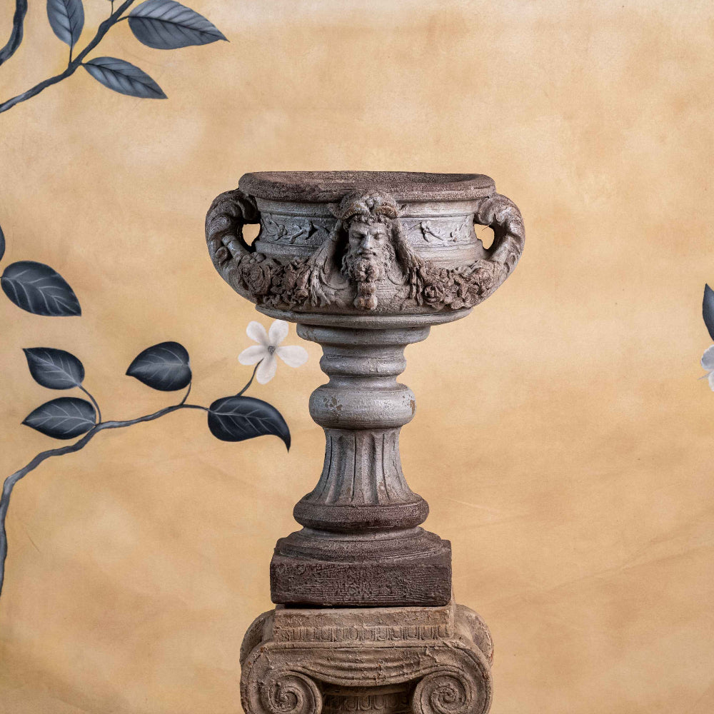 Decorative stone urn with floral archway on a beige background